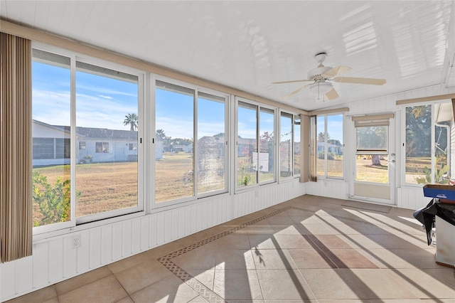 unfurnished sunroom featuring plenty of natural light and ceiling fan