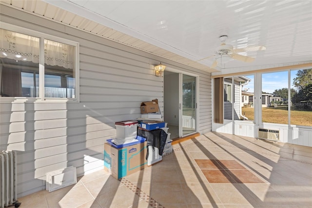 sunroom with ceiling fan, radiator heating unit, and wood ceiling