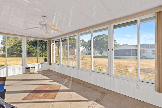 unfurnished sunroom featuring an AC wall unit and ceiling fan