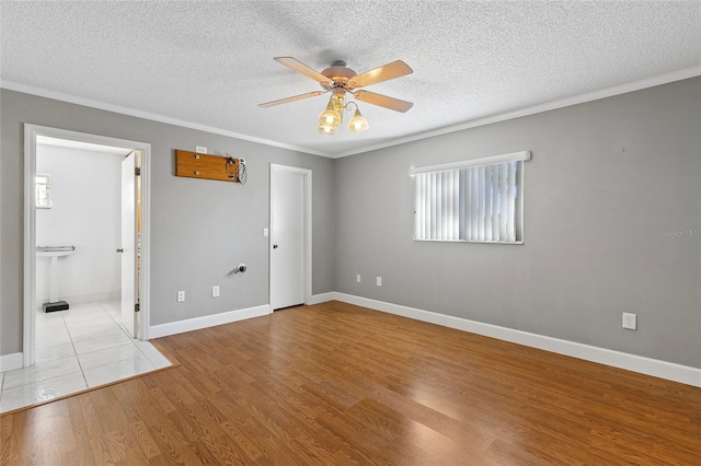 unfurnished bedroom featuring light hardwood / wood-style flooring, ensuite bath, crown molding, and ceiling fan