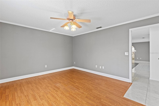 empty room with a textured ceiling, light wood-type flooring, ceiling fan, and crown molding