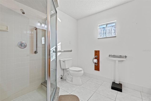 bathroom featuring tile patterned floors, a shower with door, a textured ceiling, and toilet