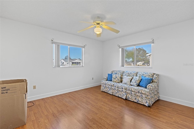 sitting room with a textured ceiling, light hardwood / wood-style floors, ceiling fan, and a healthy amount of sunlight