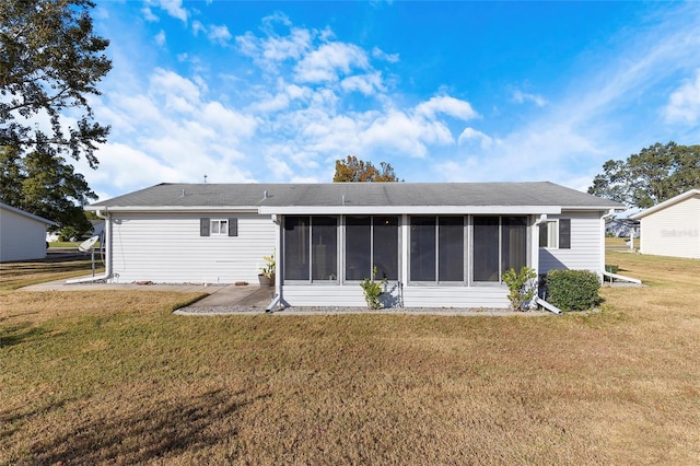 back of property with a lawn and a sunroom