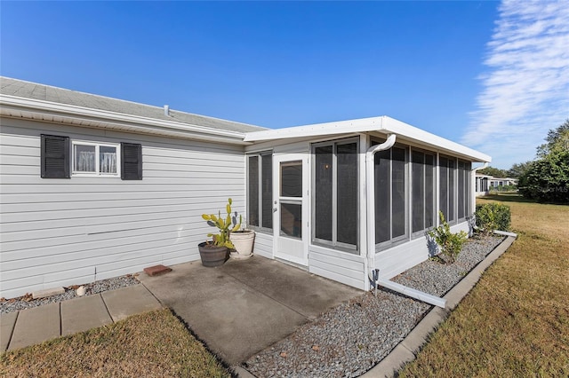 back of property with a lawn and a sunroom