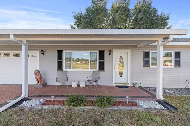 entrance to property with covered porch and a garage