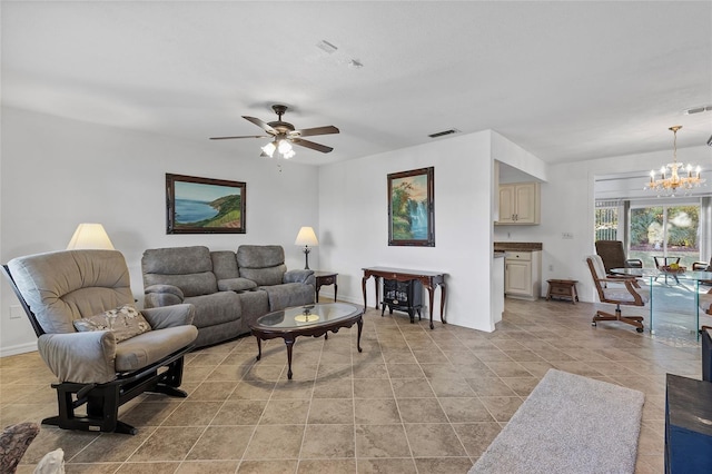 living room featuring light tile patterned floors and ceiling fan with notable chandelier