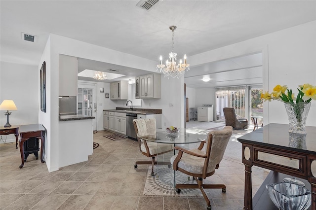 tiled dining room with sink and a chandelier