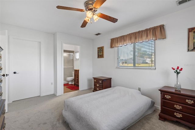 bedroom featuring light carpet, ensuite bath, and ceiling fan