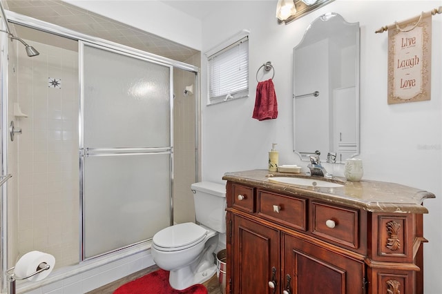 bathroom with walk in shower, vanity, and toilet