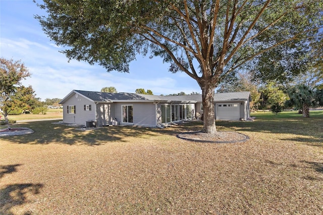 ranch-style house with a garage, a front lawn, and central air condition unit