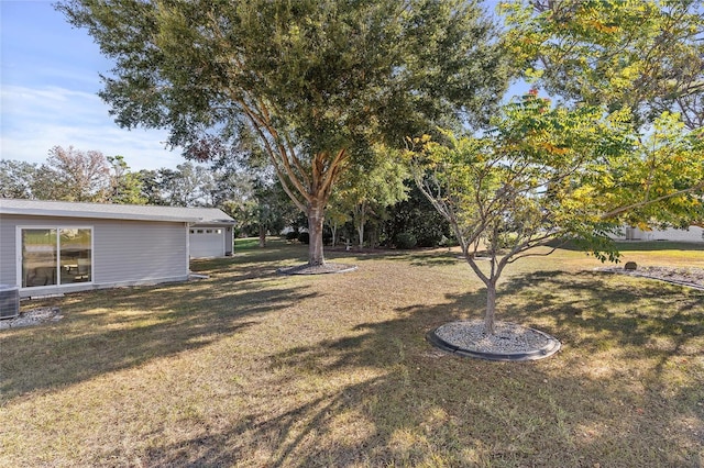 view of yard featuring a garage and central air condition unit