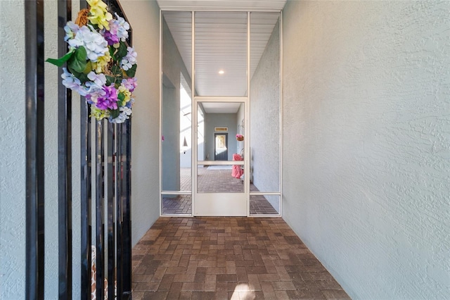 hallway with a textured wall and brick floor