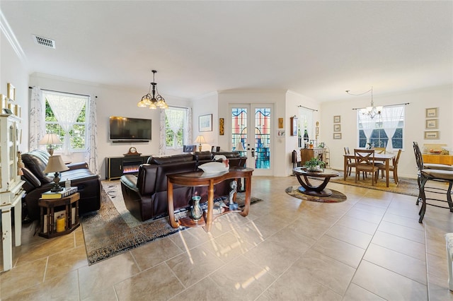 tiled living room featuring a wealth of natural light, french doors, and an inviting chandelier