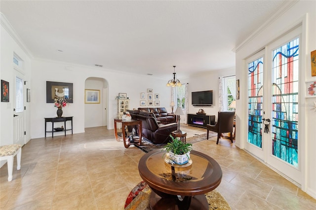 living room with french doors, an inviting chandelier, and ornamental molding