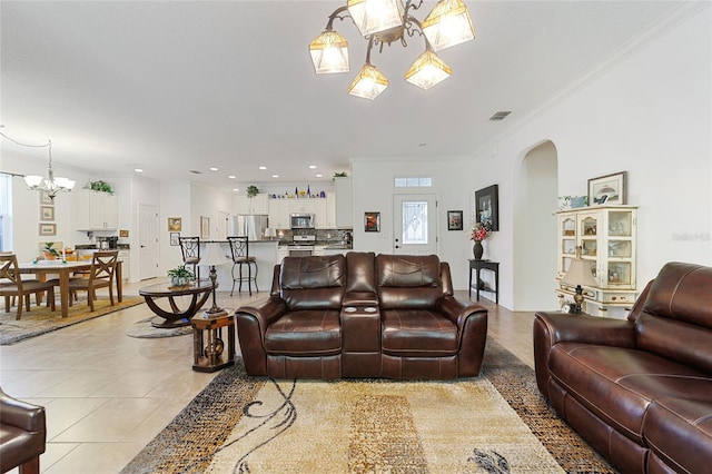 living room with ornamental molding, light tile patterned floors, and a chandelier