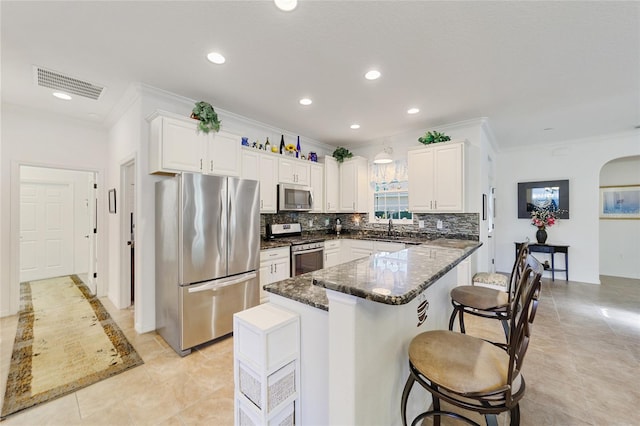 8706 SW 88th Pl, Ocala, FL 34481 - kitchen with appliances with stainless steel finishes, crown molding, decorative backsplash, white cabinets, and arched walkways