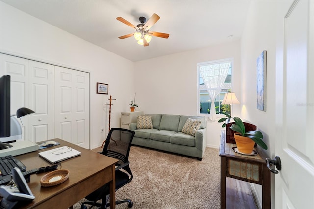 carpeted office space featuring ceiling fan