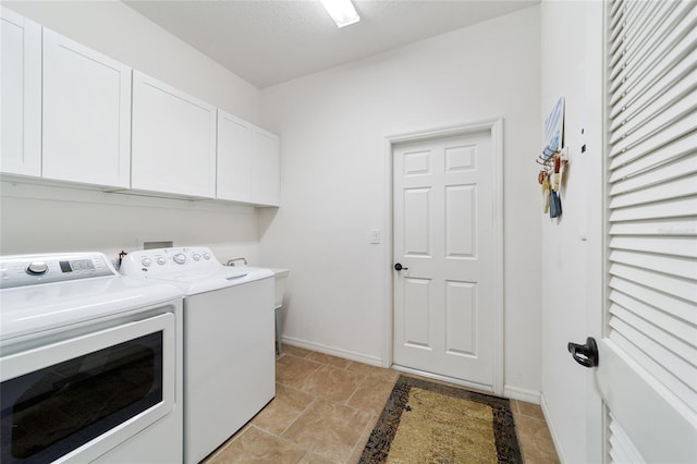 clothes washing area featuring washer and dryer and cabinets