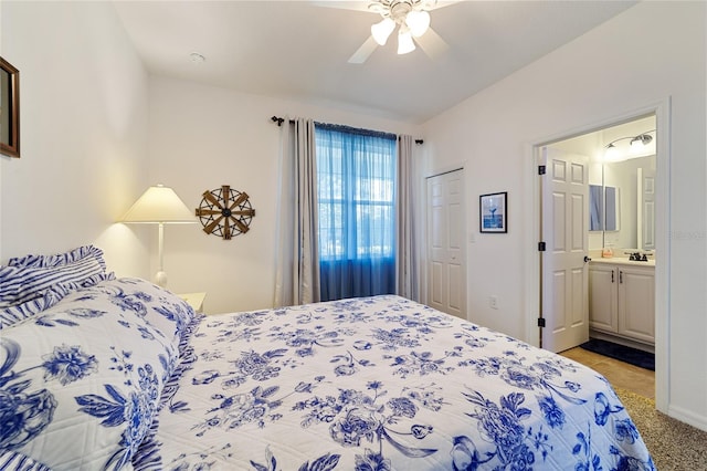 carpeted bedroom with ceiling fan and ensuite bath