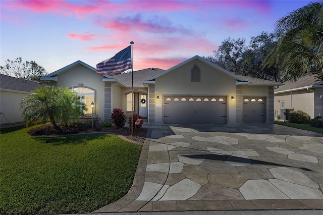 view of front of home with a garage and a lawn