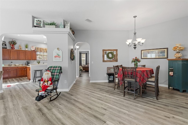 dining area featuring light hardwood / wood-style flooring, plenty of natural light, and a notable chandelier