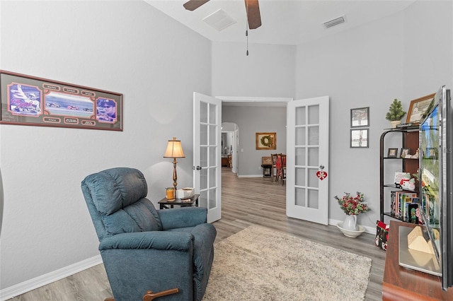 living area featuring ceiling fan, french doors, high vaulted ceiling, and hardwood / wood-style floors