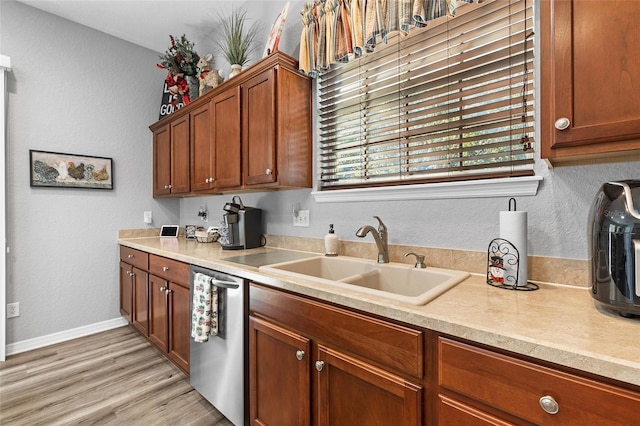 kitchen with dishwasher, light hardwood / wood-style flooring, and sink