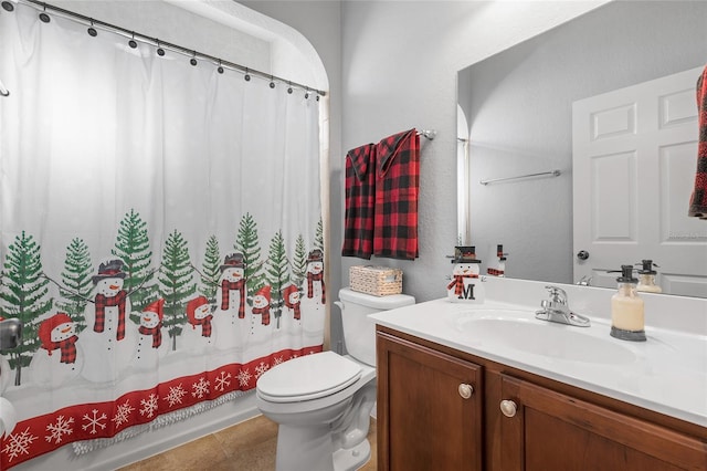 bathroom with tile patterned floors, vanity, toilet, and walk in shower