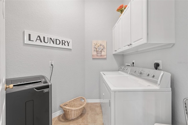 laundry area featuring cabinets, tile patterned flooring, and washing machine and clothes dryer