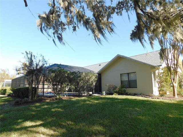 back of property featuring a lanai and a yard