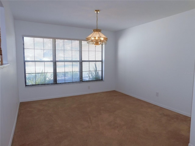 carpeted spare room featuring a chandelier