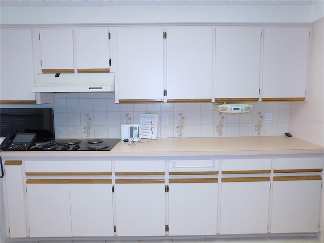 kitchen featuring backsplash, black electric cooktop, extractor fan, and white cabinetry