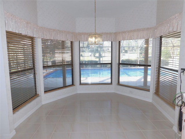 unfurnished dining area with tile patterned floors and a notable chandelier