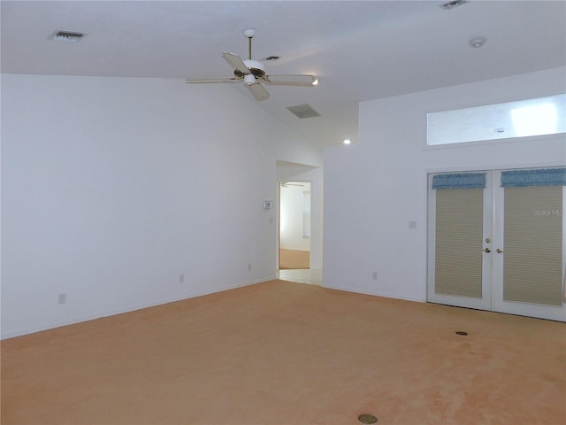 carpeted spare room featuring french doors, high vaulted ceiling, and ceiling fan