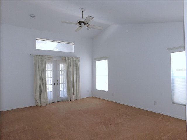 carpeted spare room with ceiling fan, french doors, and high vaulted ceiling