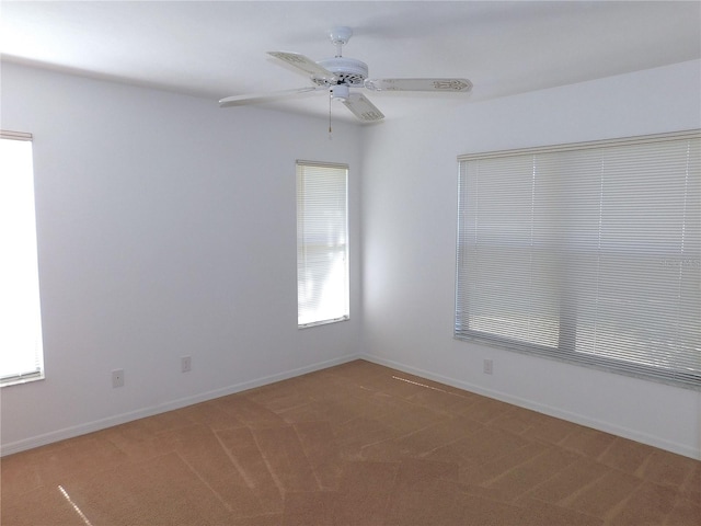 carpeted spare room featuring ceiling fan