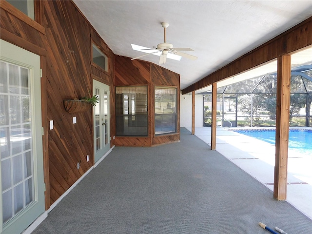 unfurnished sunroom featuring ceiling fan and vaulted ceiling