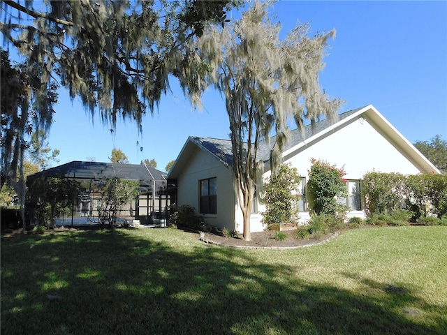 exterior space with a lanai and a yard