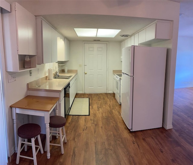 kitchen featuring sink, dark wood-type flooring, white appliances, a breakfast bar, and white cabinets