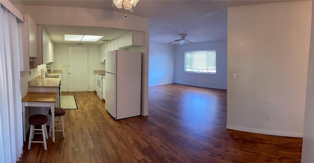 kitchen featuring ceiling fan, sink, white refrigerator, dark hardwood / wood-style floors, and white cabinetry