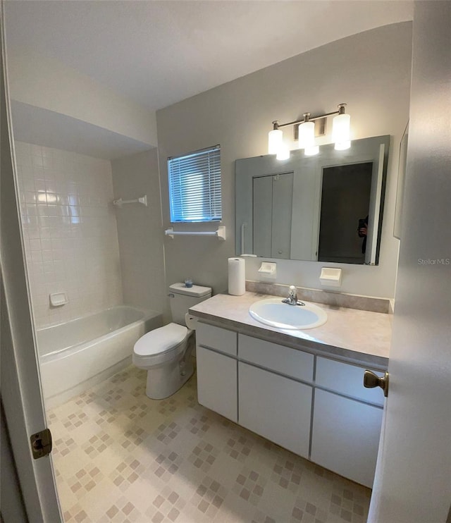 full bathroom with tiled shower / bath, vanity, and toilet