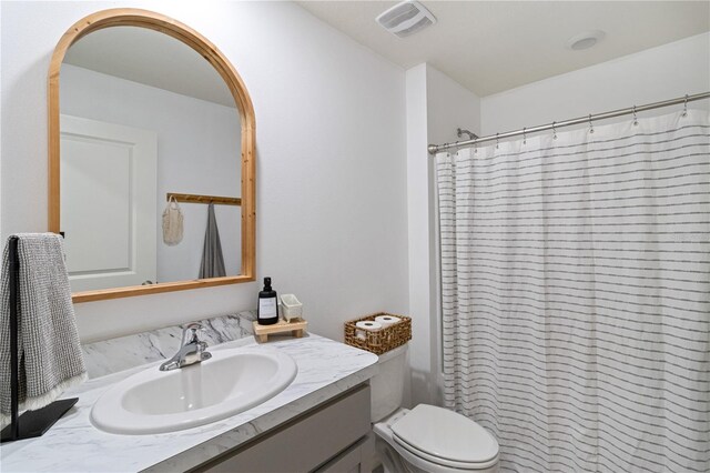 bathroom featuring a shower with shower curtain, vanity, and toilet