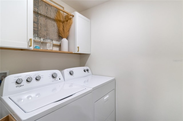 clothes washing area with cabinets and separate washer and dryer