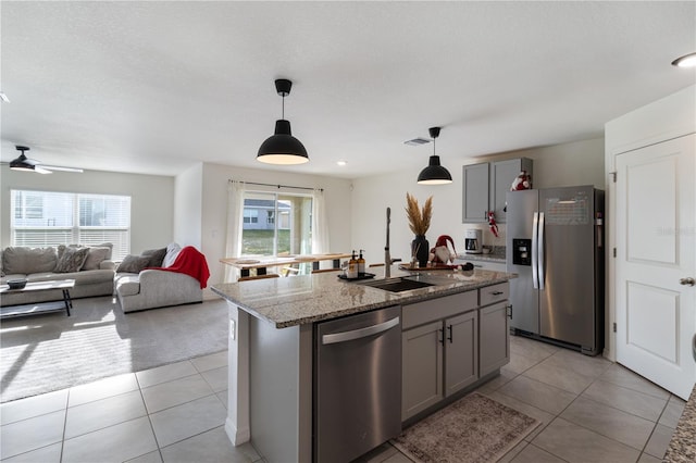 kitchen featuring gray cabinetry, a kitchen island with sink, plenty of natural light, and stainless steel appliances