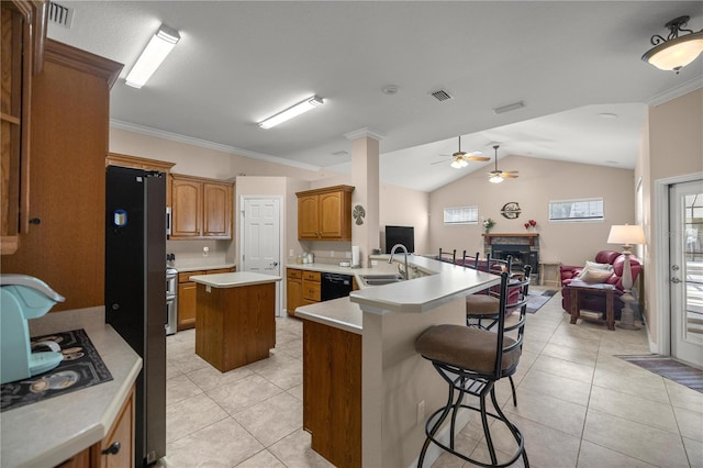 kitchen with black appliances, light tile patterned floors, a kitchen island, kitchen peninsula, and a breakfast bar area