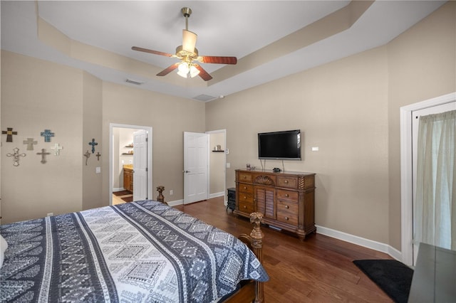 bedroom with a tray ceiling, ceiling fan, and ensuite bathroom