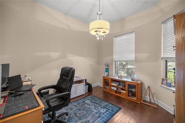 office with a notable chandelier and dark wood-type flooring