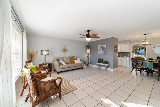 tiled living room with ceiling fan with notable chandelier, ornamental molding, and a textured ceiling