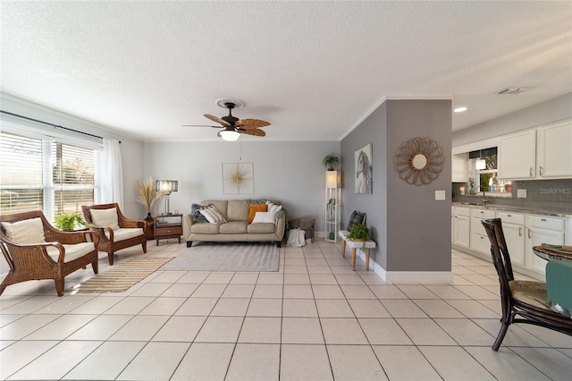 living room featuring a textured ceiling, ceiling fan, light tile patterned floors, and ornamental molding